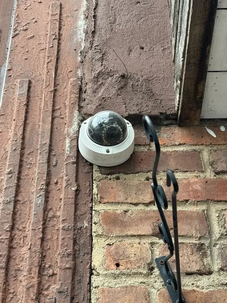 Security dome camera installed on a Brooklyn building exterior